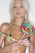 A skinny 18 year-old blond plays with her lollipop.