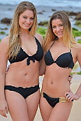 Two sexy girls take off their bikinis on the beach